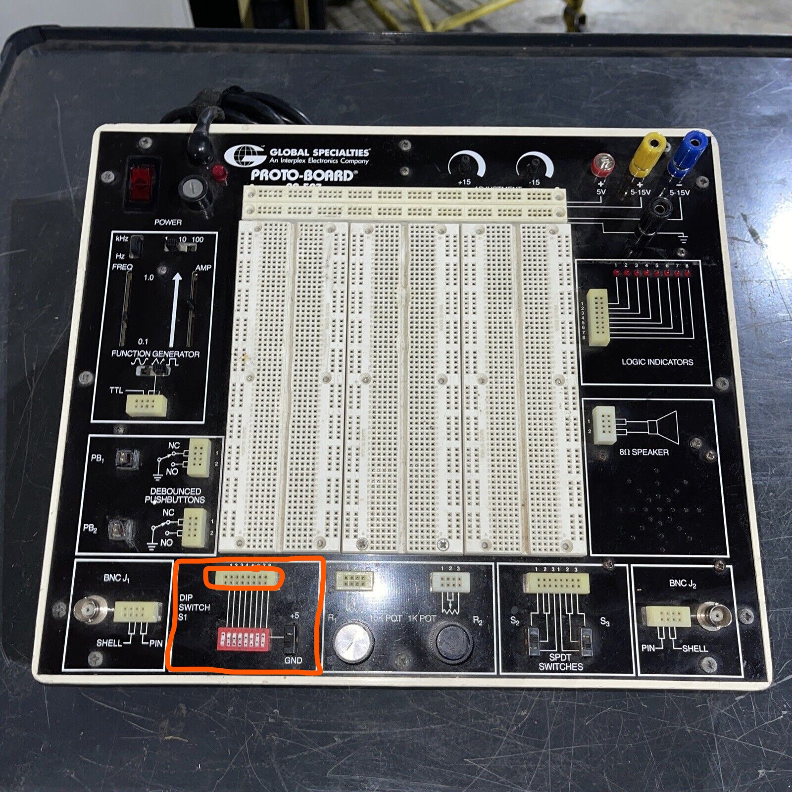 The workbench again, now showing the logic switches at the lower left. These are 8 switches that can be toggled between on an off states. Lines on the board indicate their connections to pairs of vertical sockets in an 8x2 socket strip above them.