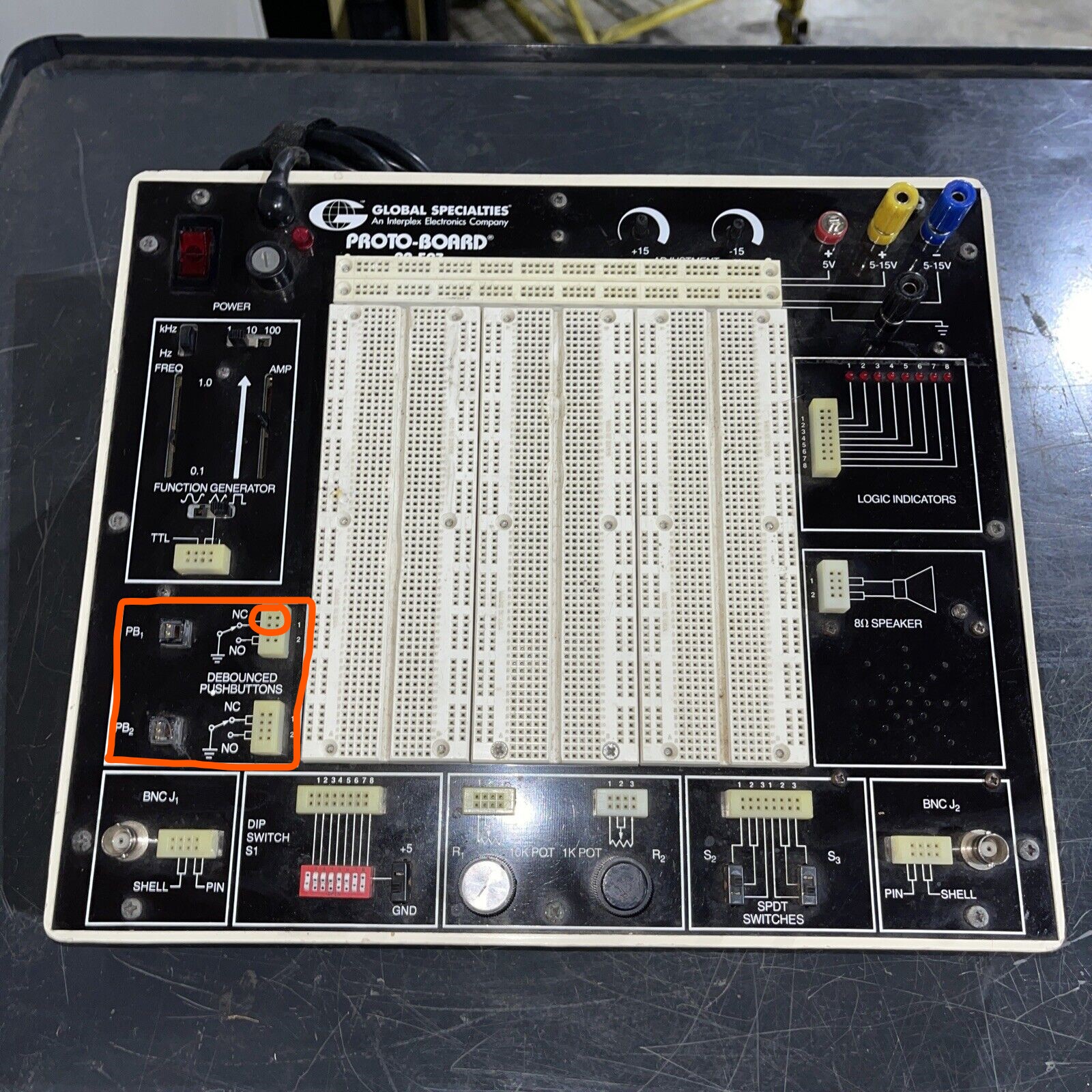 The workbench again, now showing the push-buttons at the lower left. These are 2 buttons each connected to 2x4 socket strips. The ‘on’ state of the button controls the upper 4 sockets in the corresponding strip.