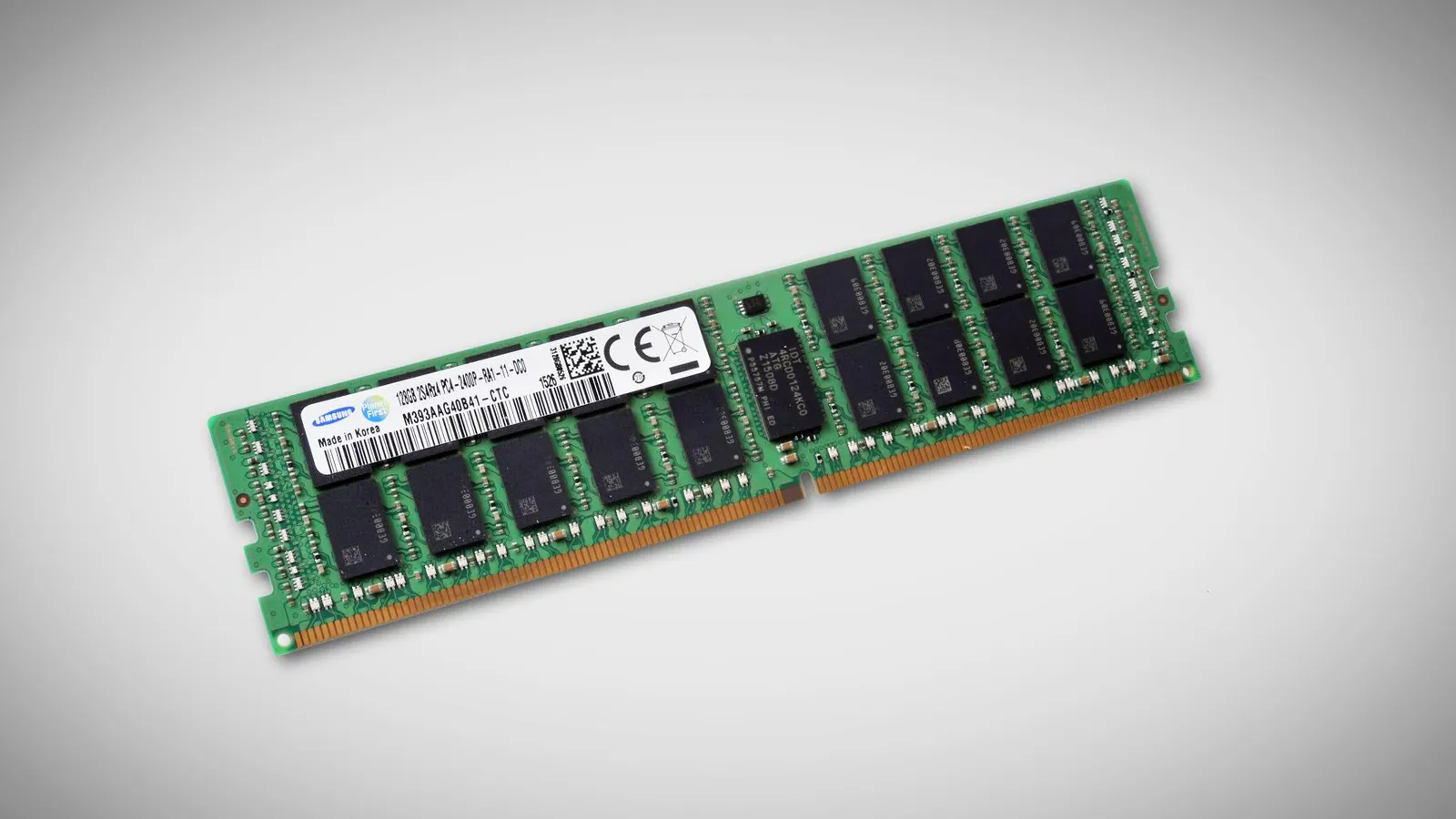A picture of a RAM chip w/ 128 GB of memory. It’s a green circuit board with orange connectors along the bottom, and the surface is mostly covered with two rows of identical black chips, with tiny rows of much smaller silver/white components between them. In the center sits a slightly larger black chip which is the controller.
